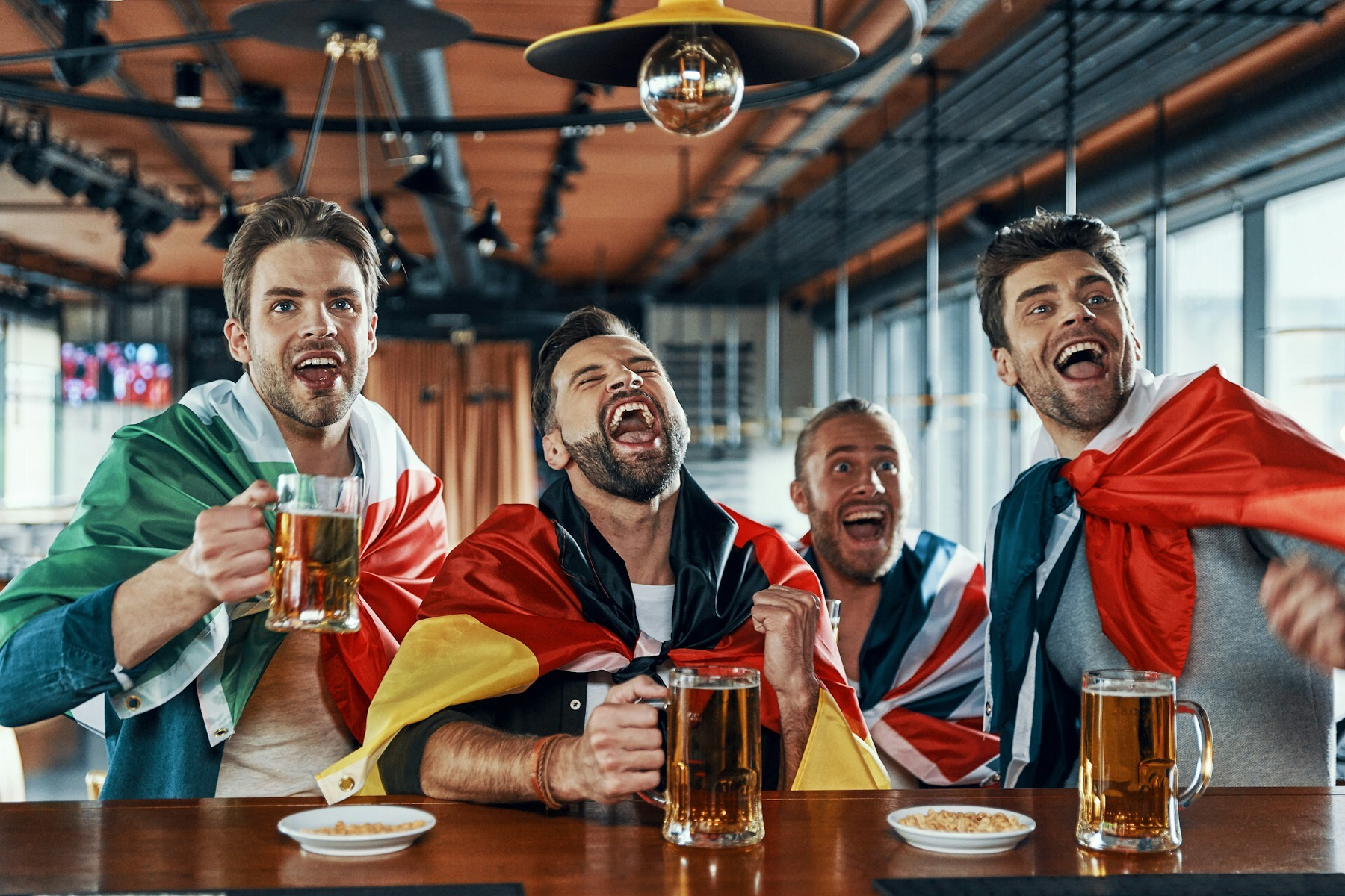 Getty Images for Unsplash+. [unsplash.com/photos/ha...](https://unsplash.com/photos/happy-young-men-covered-in-international-flags-drinking-beer-and-watching-sport-game-while-sitting-in-the-pub-4R4qVqQU8tk)